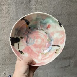 unika skål. håndlavet drejet . ret `levende` skæv i formen. Glasur på porcelæn. skål. evt til salat, pasta, morgenmad. lyserød, grøn og sort glasur.