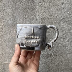 `grrrr kop `unika håndlavet keramik kop med ansigt. Håndlavet og modeleret i stentøjsler. glaseret sort, grå og lidt blå. Ansigtskop. kopper.