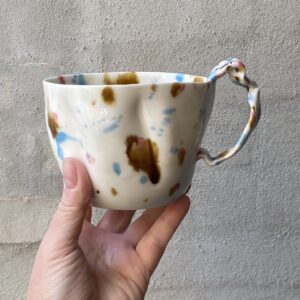 unik i glasur og skæv og levende i formen. Håndlavet og drejet keramik. Porcelæn. Lille personlighed. unik kop med ansigt.