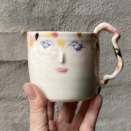 unik i glasur og skæv og oval i formen. Håndlavet og drejet keramik. Porcelæn. Lille personlighed. unik kop med ansigt. med særlig glasering.