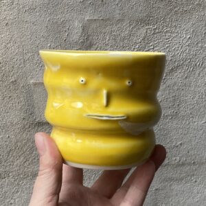 unika håndlavet keramik kop med 3 ansigter. Håndlavet og modeleret i porcelænsler. glaseret i skøn gul. ujævn glasering unikkop. Ansigtskop.