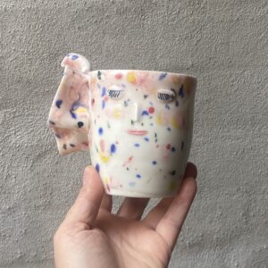 unik i glasur og form oval og levende form. Håndlavet og drejet keramik. Porcelæn. Lille personlighed. unik kop med flæser. Ansigtskop. Konfetti glasering.