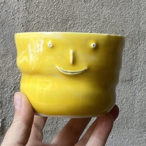 unika håndlavet keramik kop med 3 ansigter. Håndlavet og modeleret i porcelænsler. glaseret i skøn gul. ujævn g unikkop. Ansigtskop.