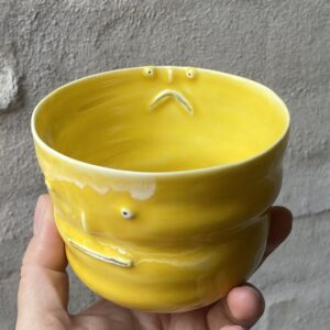 unika håndlavet keramik kop med 3 ansigter. Håndlavet og modeleret i porcelænsler. glaseret i skøn gul. ujævn g unikkop. Ansigtskop.