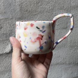 Konfettikop med svagt lyserødt skær. unik i glasur og form. Håndlavet og drejet keramik. Porcelæn. unik kop med glasering.