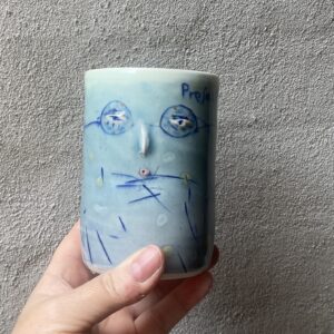 unik i glasur og form. Håndlavet og drejet keramik. Porcelæn. en lille personlighed. unik kop med glasering. ansigtskop. teks på koppen- professor i pseudovidenskab.