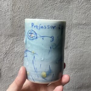 unik i glasur og form. Håndlavet og drejet keramik. Porcelæn. en lille personlighed. unik kop med glasering. ansigtskop. teks på koppen- professor i pseudovidenskab.
