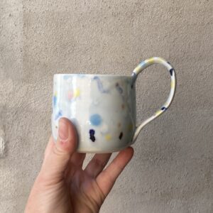 Konfettikop med svagt lyseblåt skær. unik i glasur og form. Håndlavet og drejet keramik. Porcelæn. unik kop med glasering.